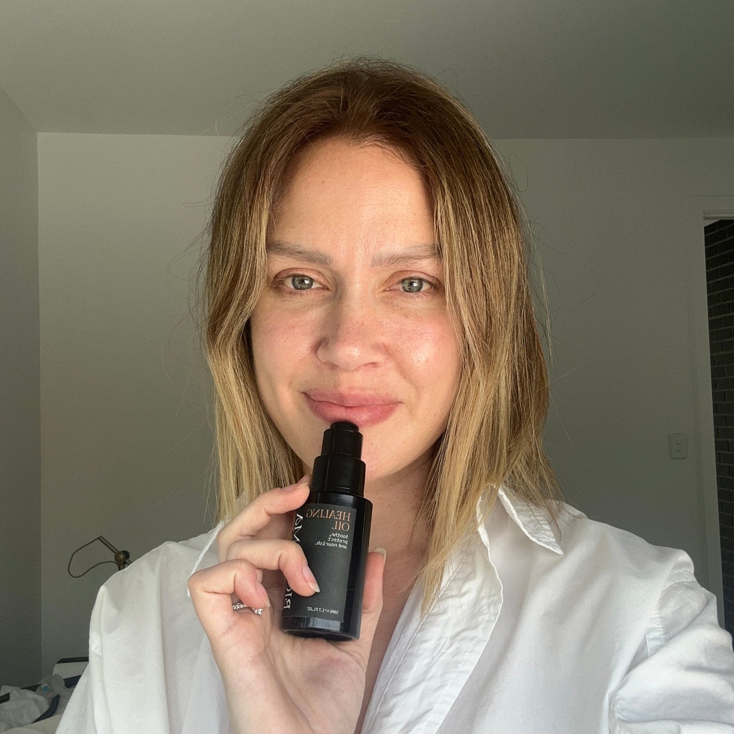 Postpartum mother holding Biomama Skincare Healing Oil