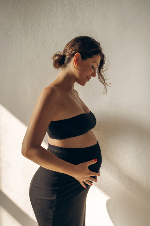 Pregnant women serenely holding her stomach