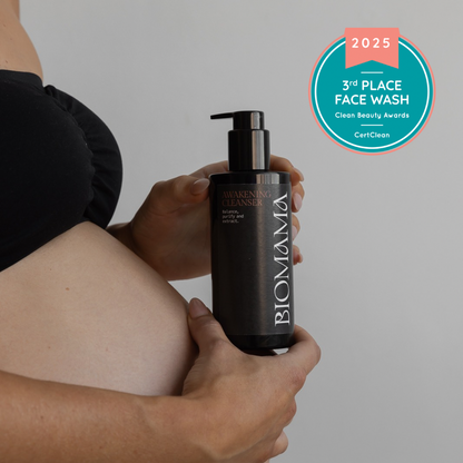 Biomama Skincare award winning Awakening Cleanser in the hands of a pregnant women